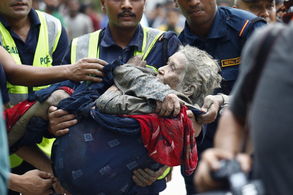 An elderly woman is being rescued from the floods of Nepal that occurred in August 2026.